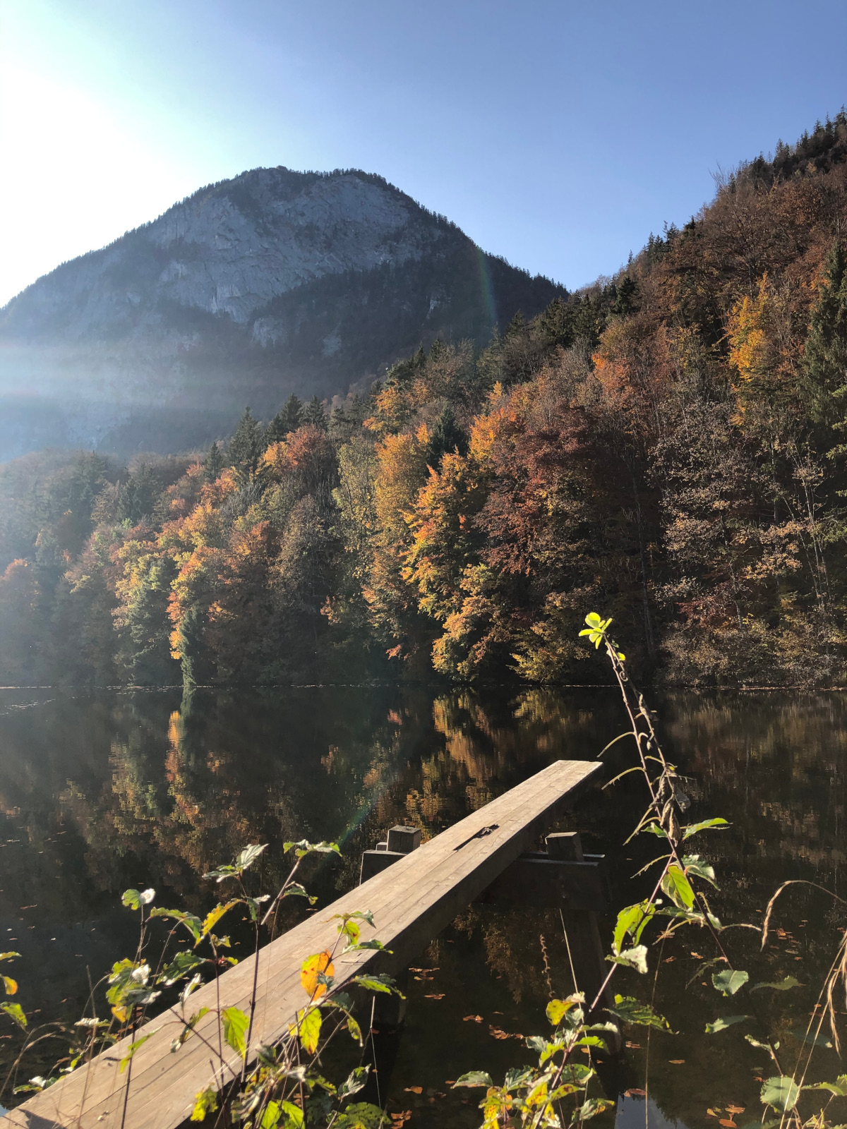 Ruhiger Bergsee mit Spiegelung und Steg als Symbol für neue Klarheit